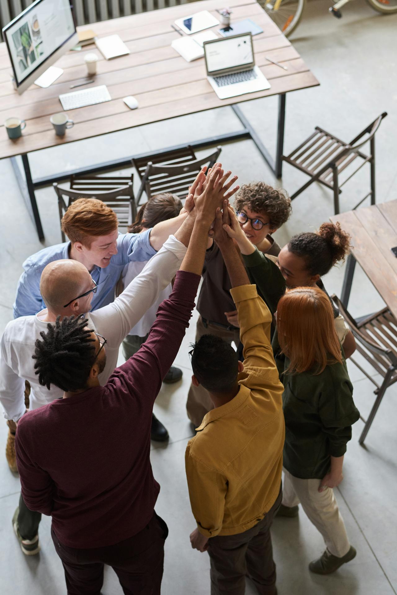 Team members joining hands in a group high five Team members joining hands in a group high five